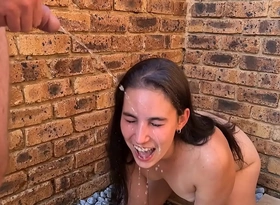 Slow motion face piss respecting girl's face outside human toilet golden shower