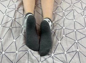 Unreserved with Long Legs Caresses Her Feet in Gray New Year Socks with Deer